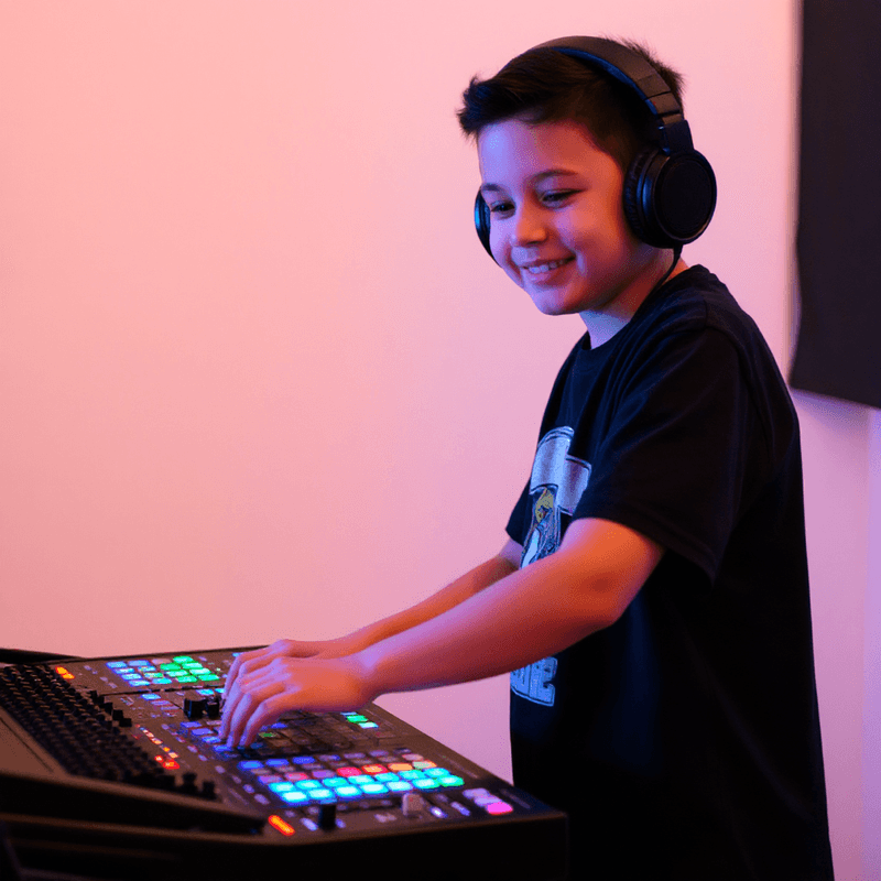 a boy wearing headphones using a production mixer.png